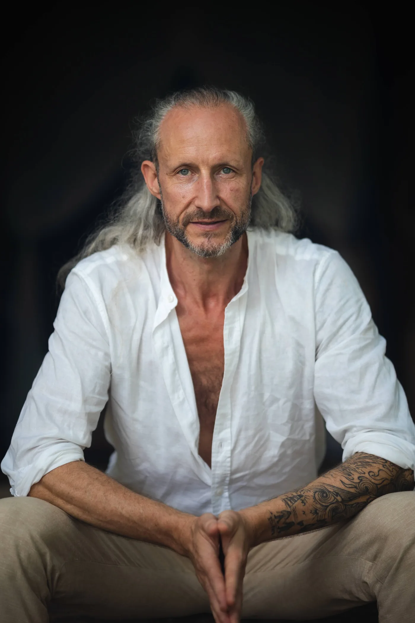 Steve Shiva in a white shirt, hands steepled, looking straight at the camera